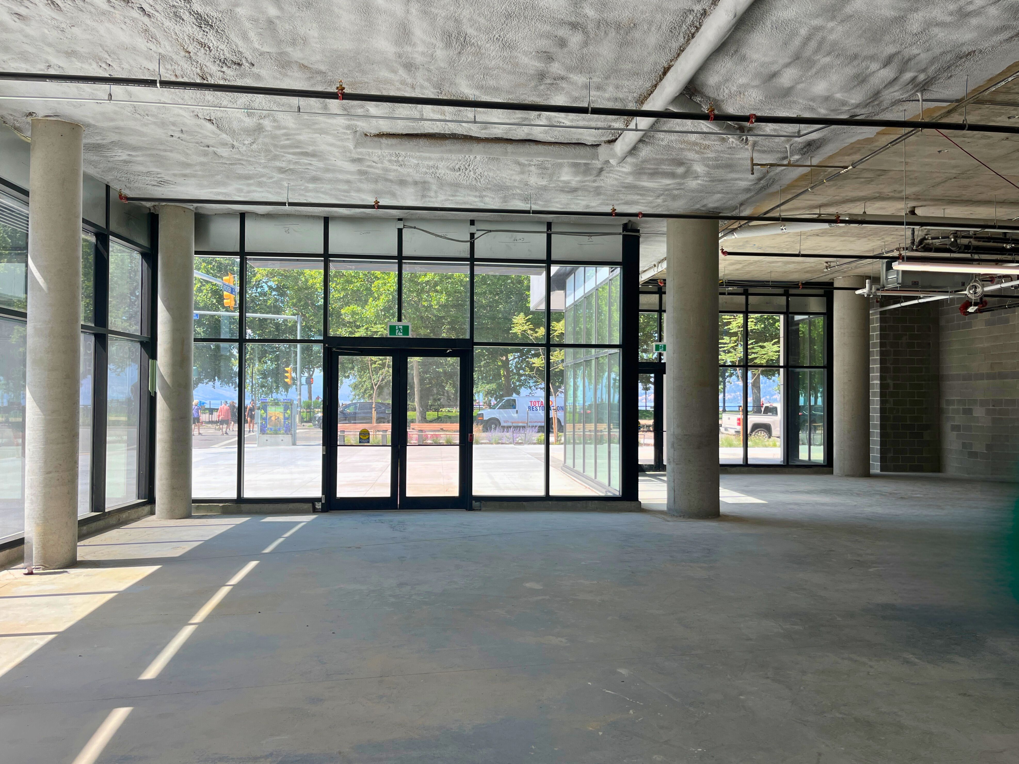 Interior photo of entry area of a new, vacant commercial space with sunshine outside