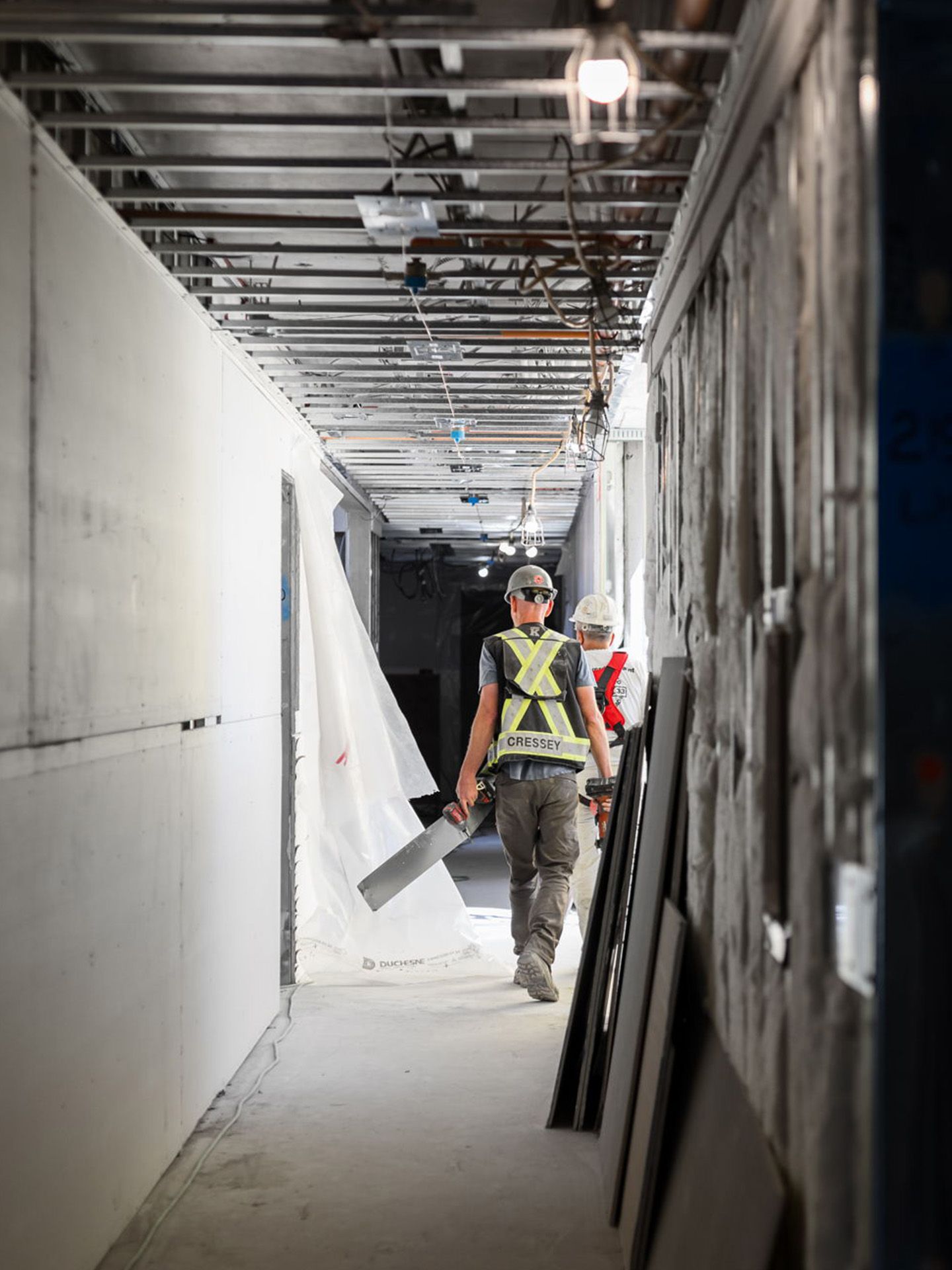 Construction worker walking down hallway in sunlight