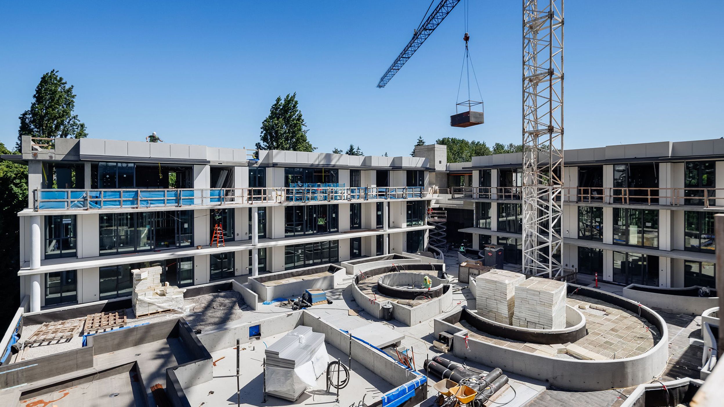Residential building's amenity courtyard under construction on sunny day