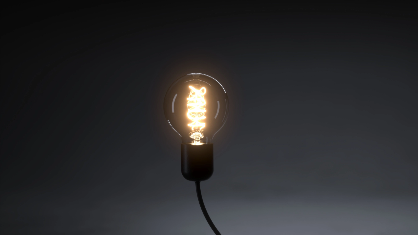 A glowing light bulb with a visible filament against a dark, minimalist background.