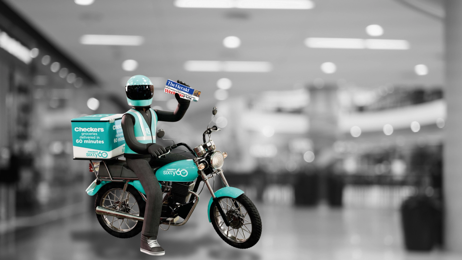 Guy on a motorcycle, holding a newspaper