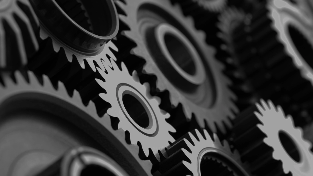 Close-up of interlocking black gears of various sizes, showcasing mechanical complexity and industrial design