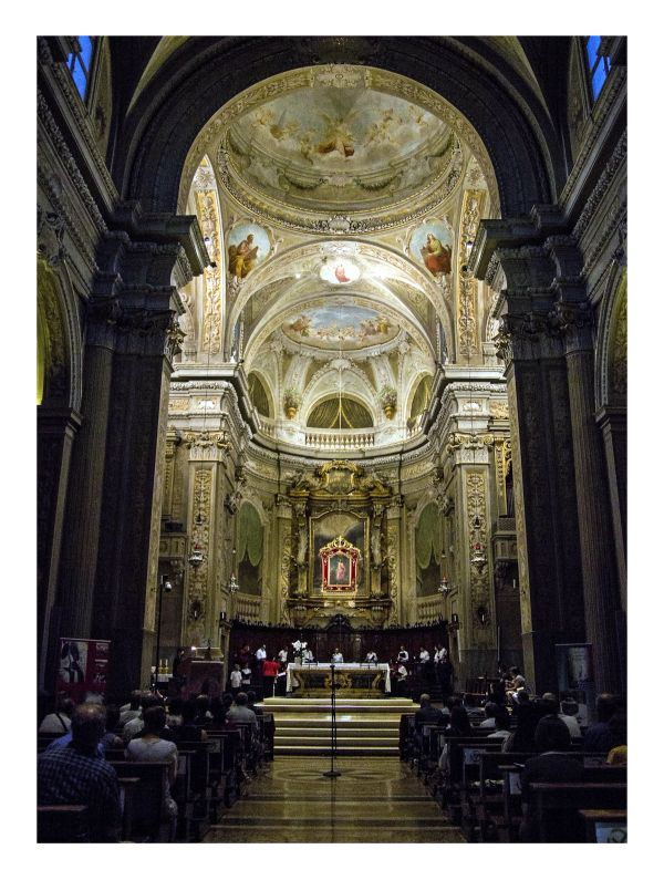 La chiesa vista dalla navata: il pubblico distanziato tra i banchi e, in fondo, il coro davanti all’altare sotto la cupola affrescata