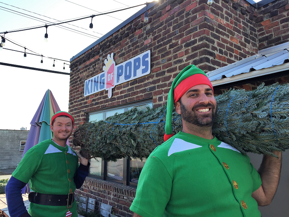 Two Tree Elves with a fresh-cut Fraser Fir outside King of Pops