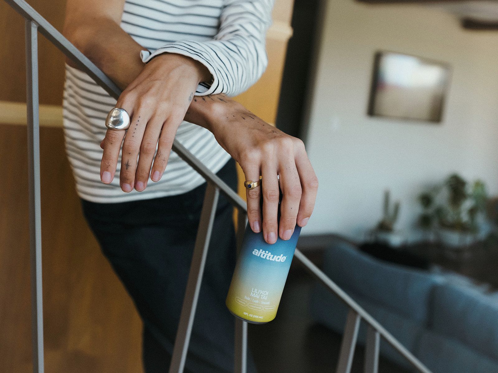 Altitude Lili'Koi Mai Tai held by person standing on stairs