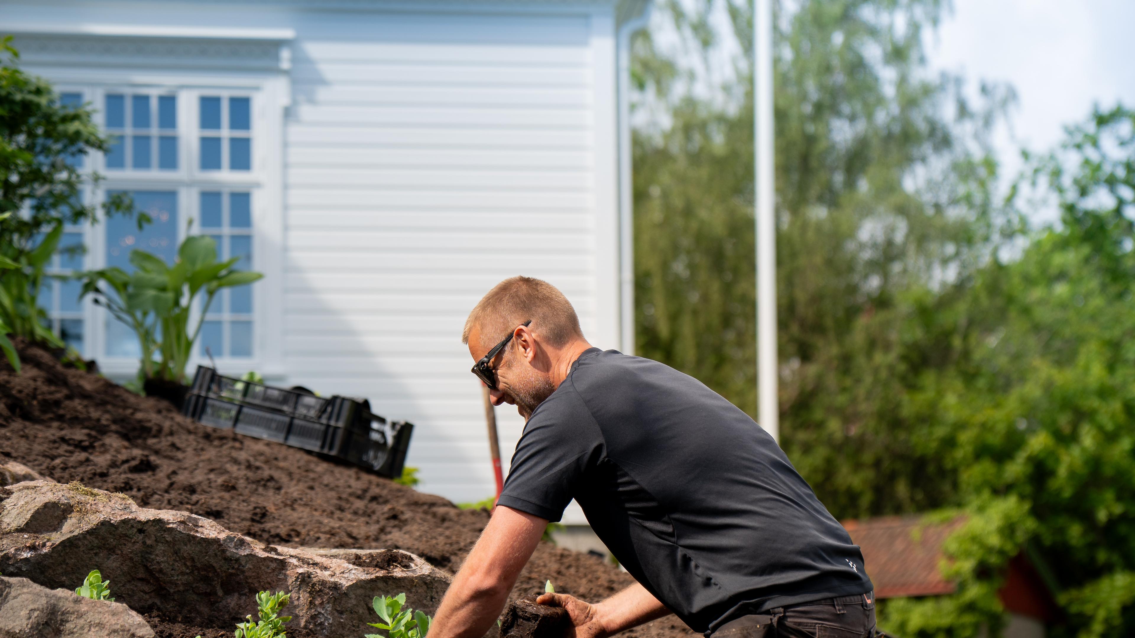 Gartner planter i steinbed mellom store natursteiner