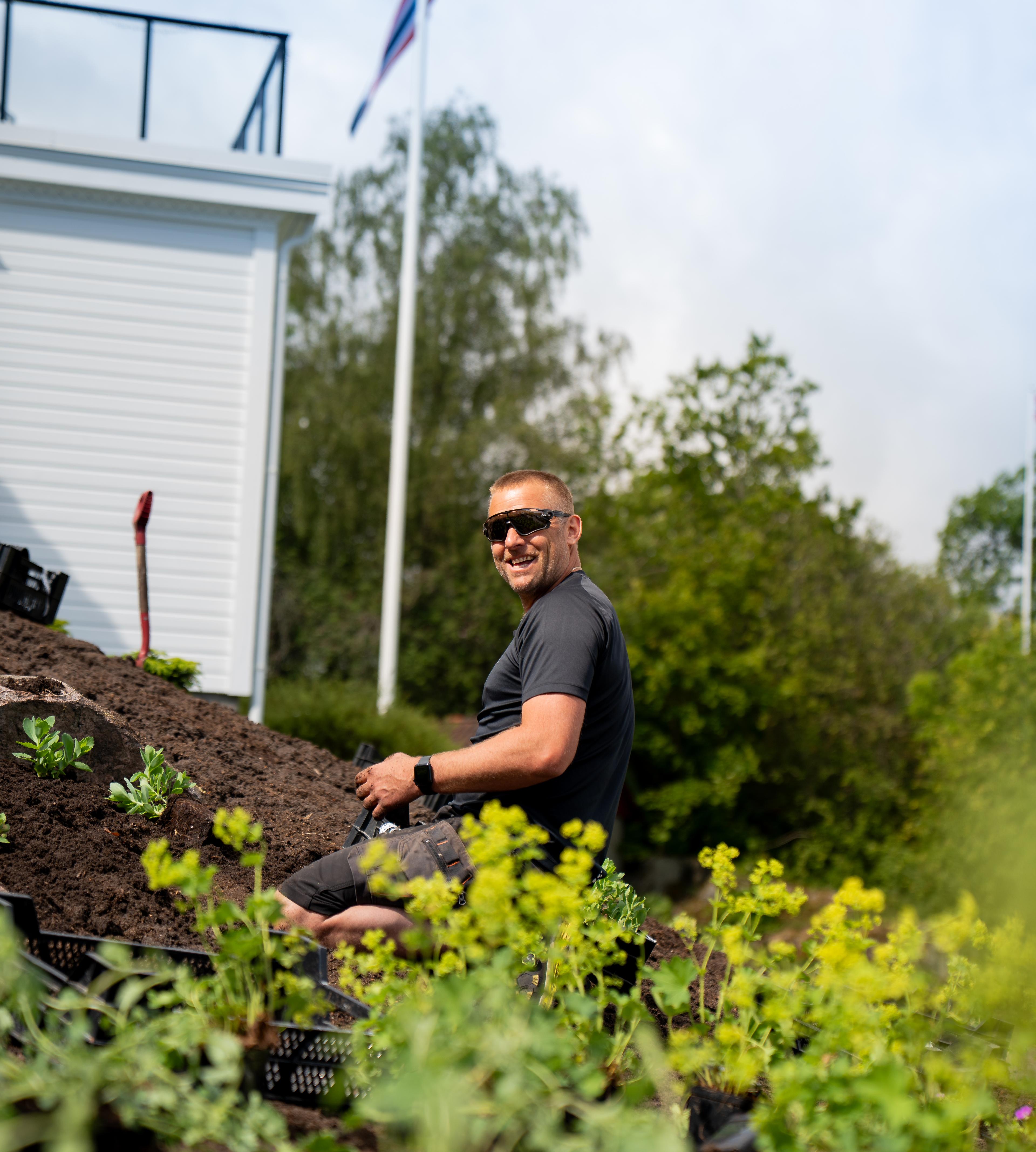 Anleggsgartner i arbeid med nytt uteanlegg i skråning