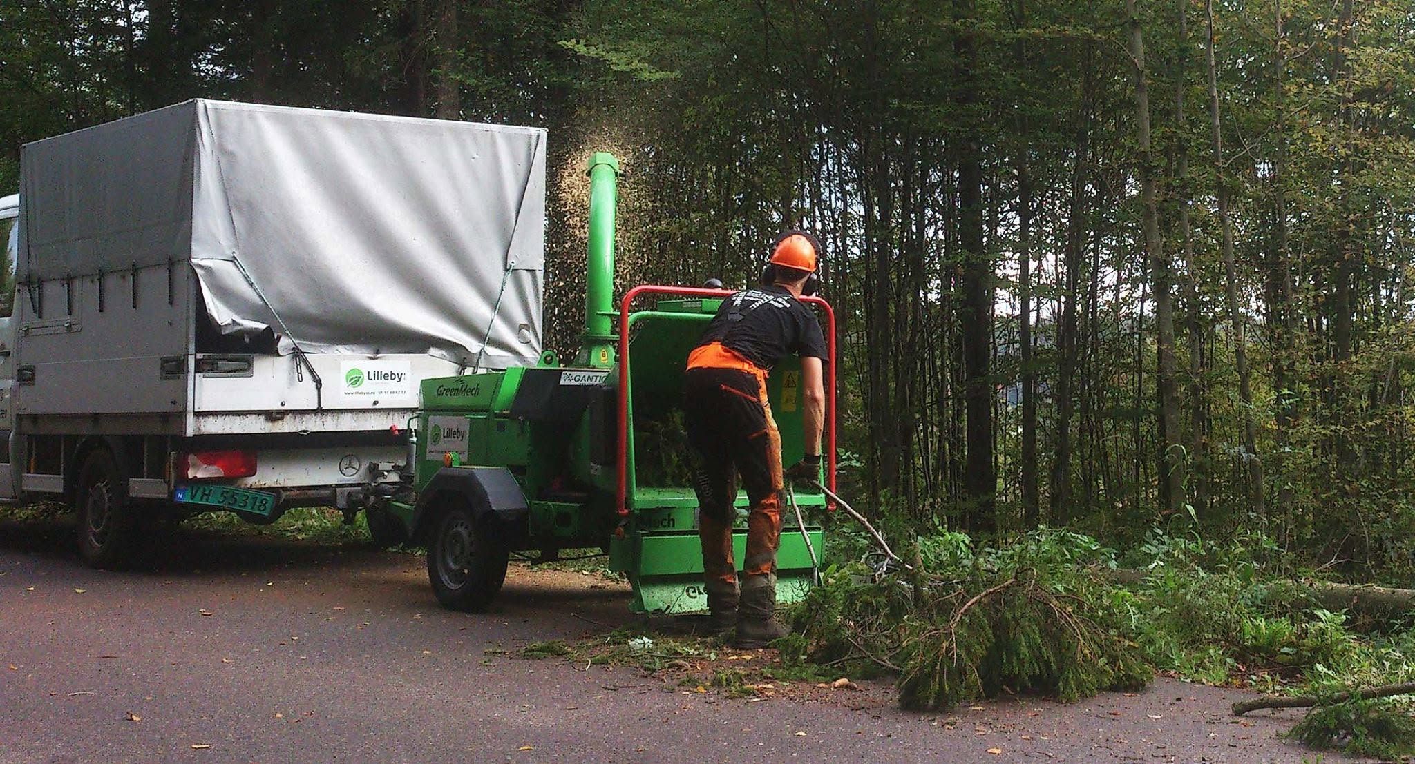 Flishugger i arbeid i skogkanten ved lastebilen