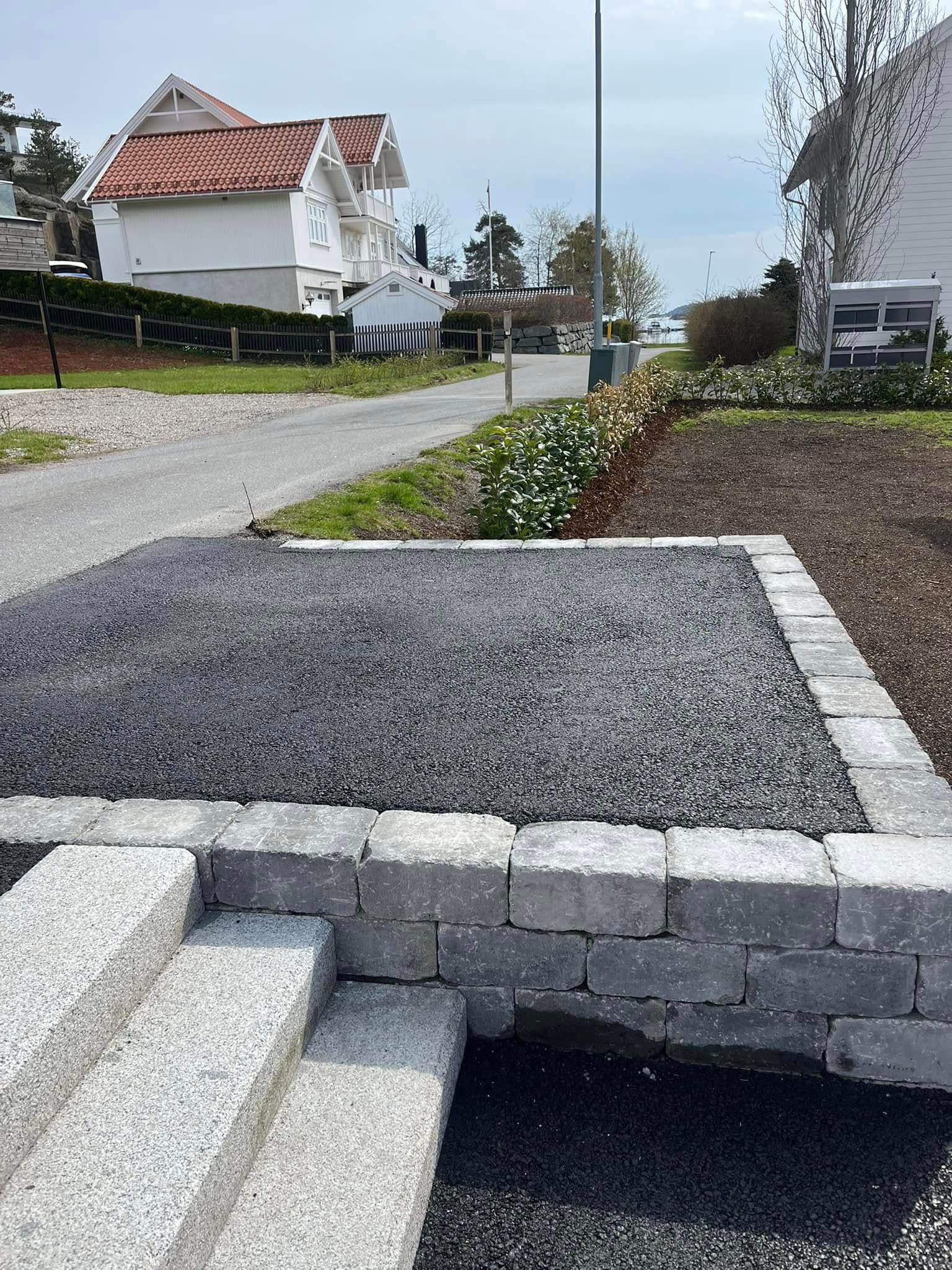 Asfaltert oppkjørsel med granittkantstein og trapp