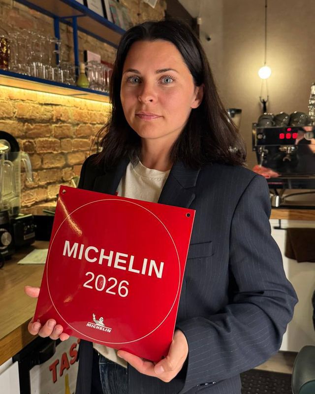 Ludmila Zhilina, Wine Curator of LOWINE, holding the MICHELIN 2026 plaque at the bar