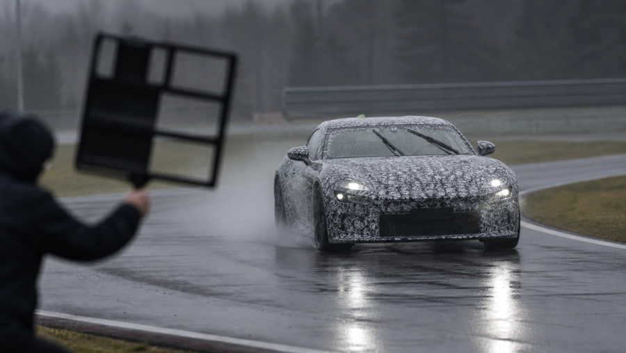 Camouflaged grand-touring development mule testing on a wet proving ground