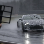 Camouflaged grand-touring development mule testing on a wet proving ground