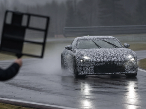 Camouflaged grand-touring development mule testing on a wet proving ground