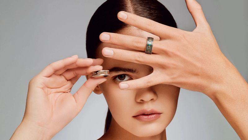 A person interacting with a smart ring on their finger, with data visualisations in the background.