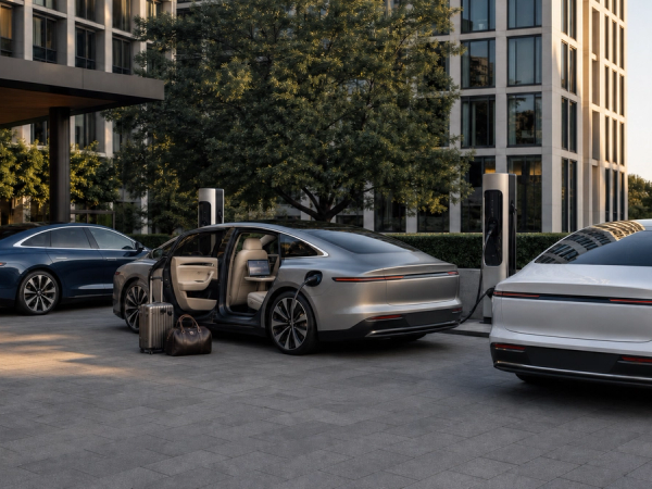 Three unbranded luxury electric sedans at a hotel charging court with luggage