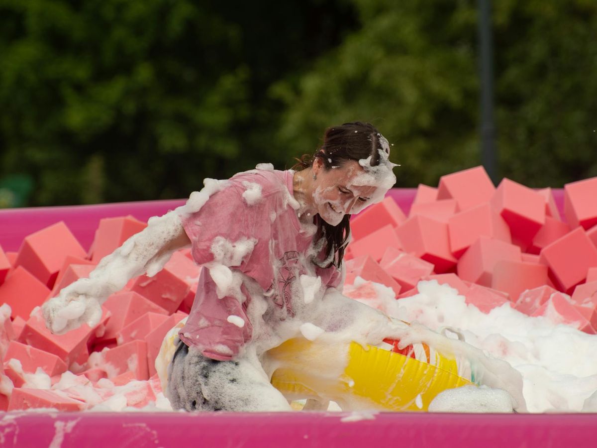 Young woman enjoying a colorful foam party in Vilnius, Lithuania.