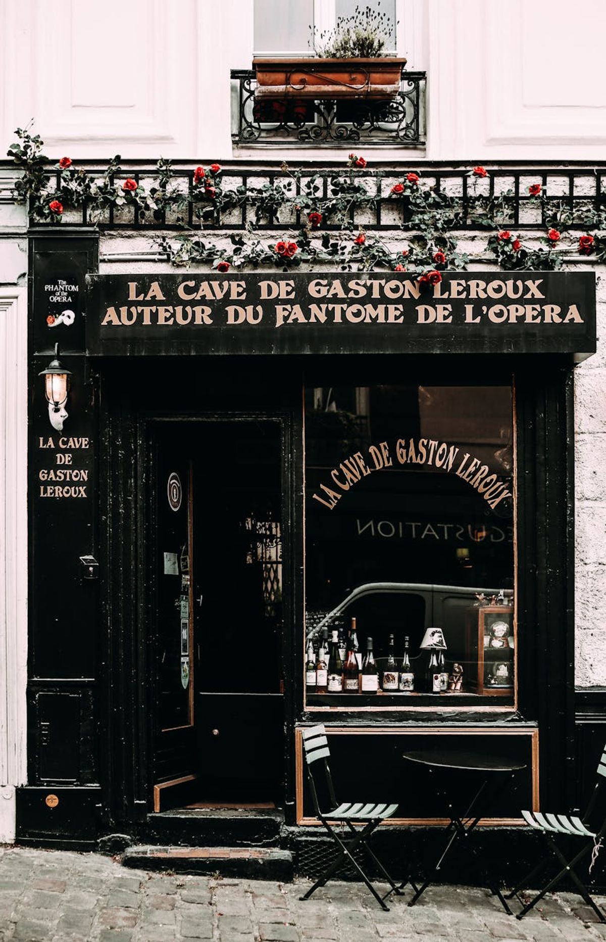 A quaint vintage cafe with classic decor and vibrant floral accents on a Paris street.