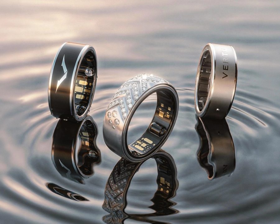 Three VERTU AI Aura Rings on water — black, diamond pavé, and silver — official product photography for the Care Five-Piece Set