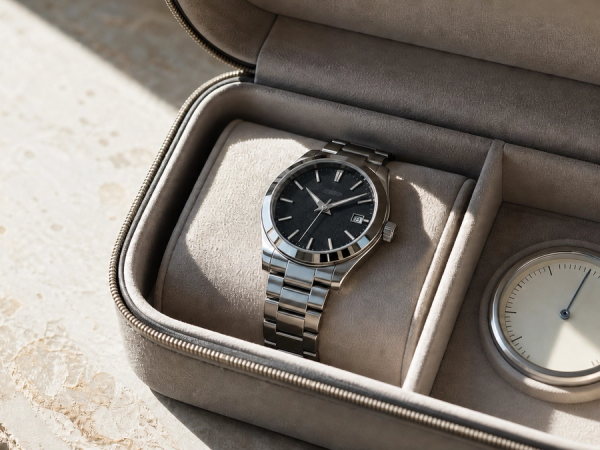 A mechanical watch resting in a shaded travel case beside a temperature gauge, with condensation and direct sun clearly avoided