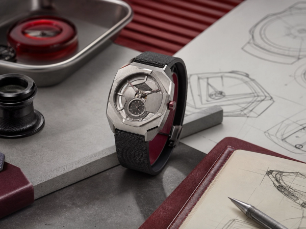 Contemporary geometric wristwatch displayed beside a loupe, sketchbook and collector evaluation card