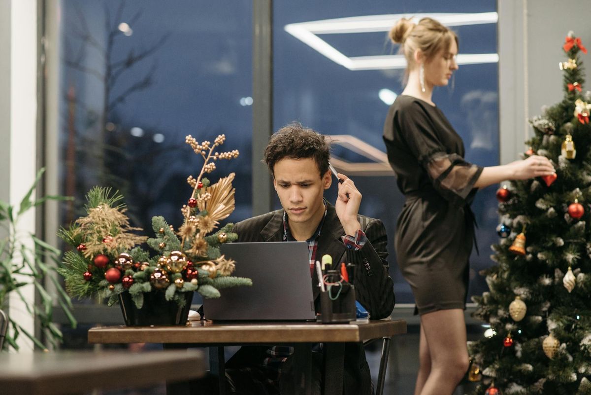 A modern office with Christmas decorations and coworkers celebrating the holiday season.
