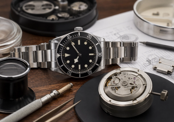 Eine gebrauchte mechanische Uhr, die neben Serviceunterlagen und Armbandteilen geprüft wird