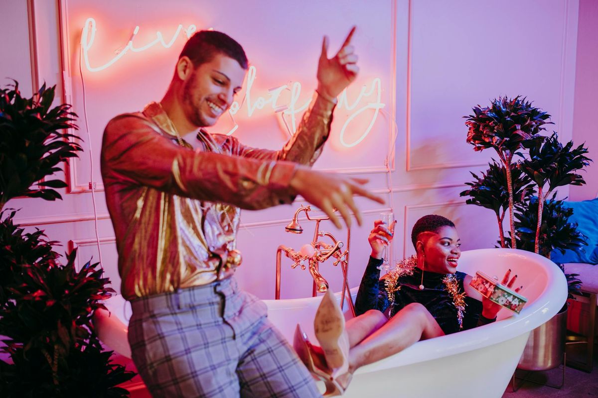 A lively celebration with friends featuring neon lights and festive decor in an indoor setting.
