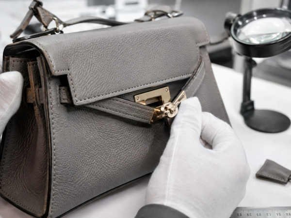 Designer handbag inspected with magnification for construction, hardware and authenticity evidence
