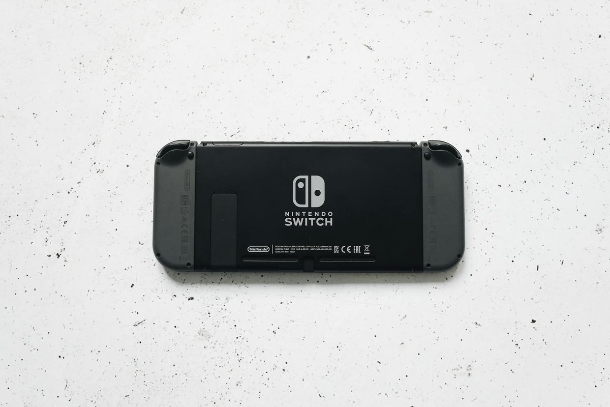 A close-up of a Nintendo Switch console placed on a textured marble surface, highlighting the device's sleek design.