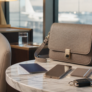 Luxury crossbody bag arranged with travel essentials in an airport lounge