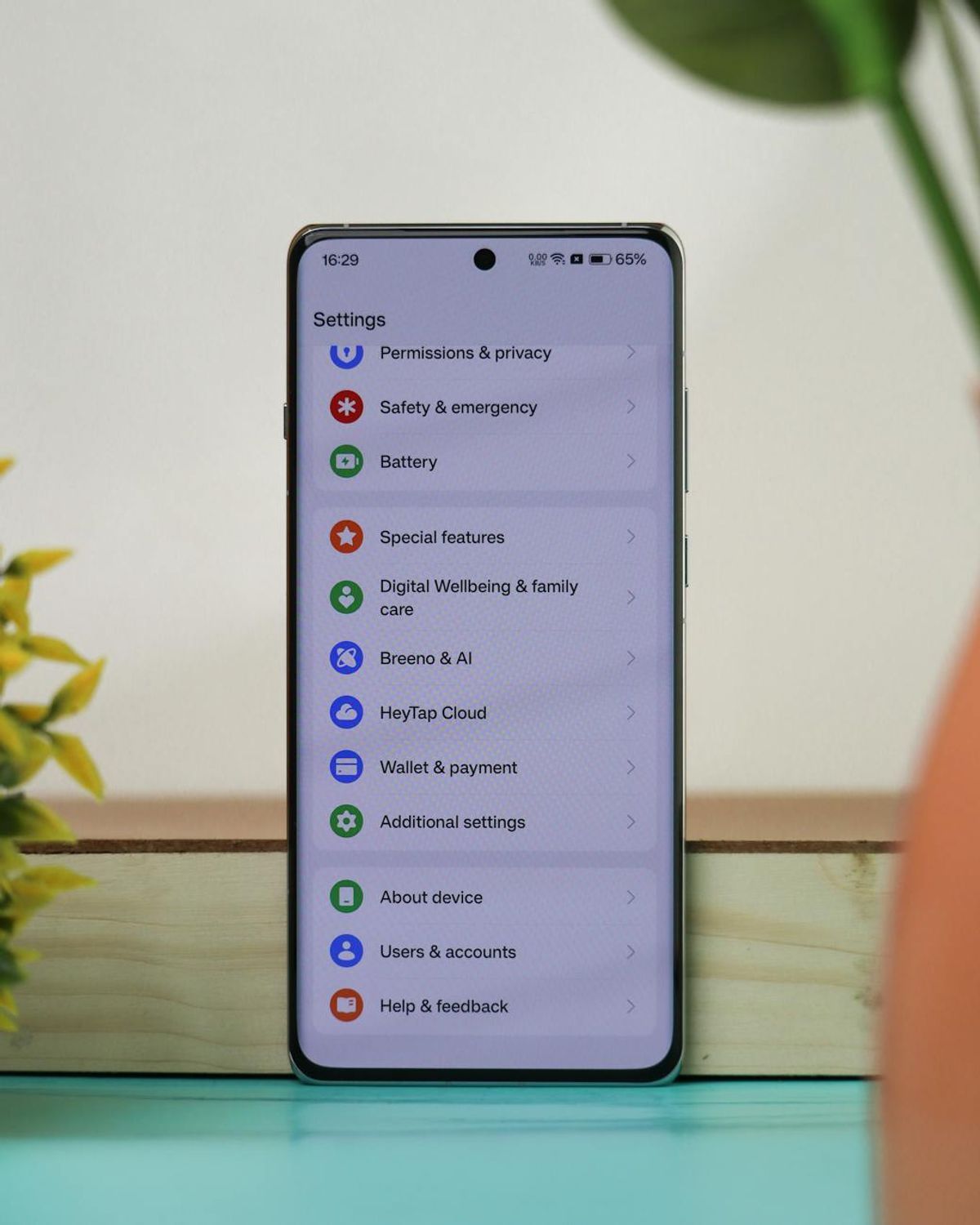 A smartphone on a desk with a settings screen, showcasing various menu options in an office setting.