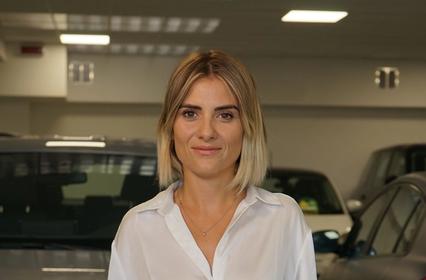 Ritratto di Carola Artuso nel garage piena di macchine