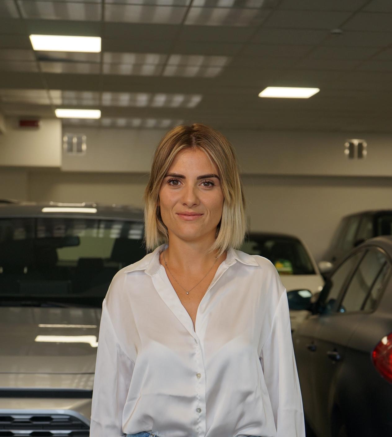 Ritratto di Carola Artuso nel garage piena di macchine