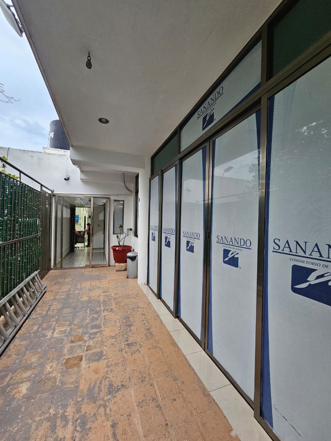 Corredor exterior techado que lleva a la unidad SANANDO
