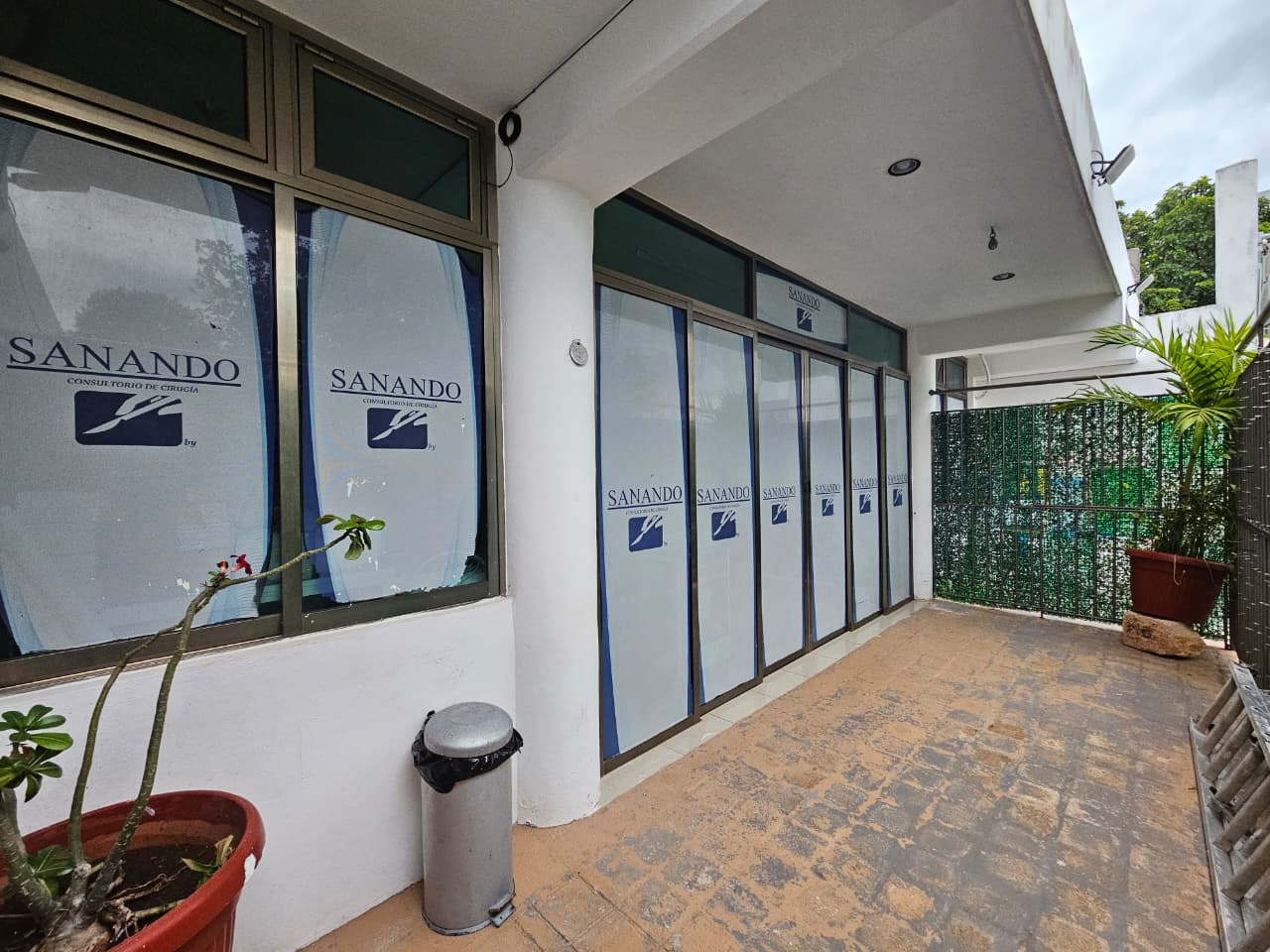 Fachada de la unidad SANANDO, consultorio de cirugía, con sus ventanales rotulados