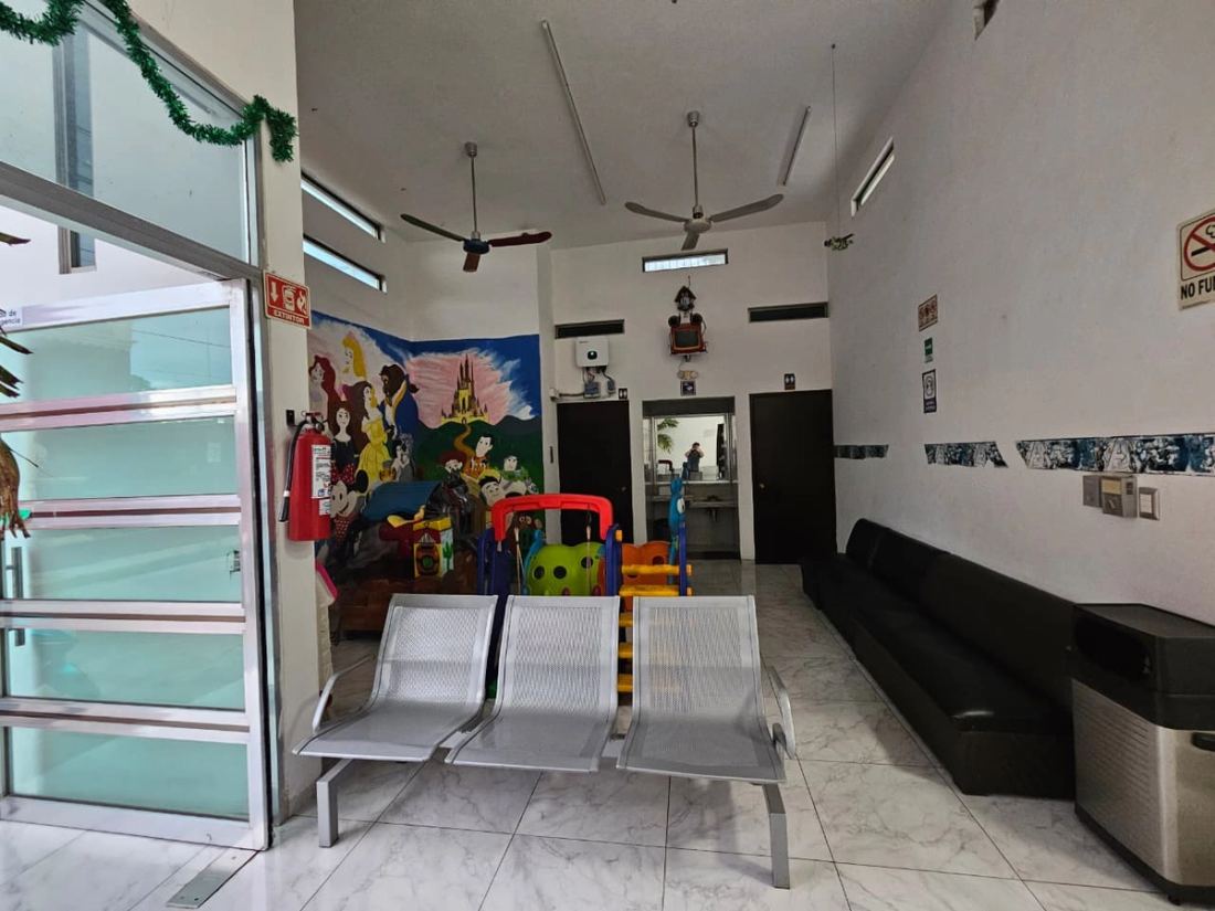 Área infantil y sillón de espera, con el lavabo y los sanitarios al fondo
