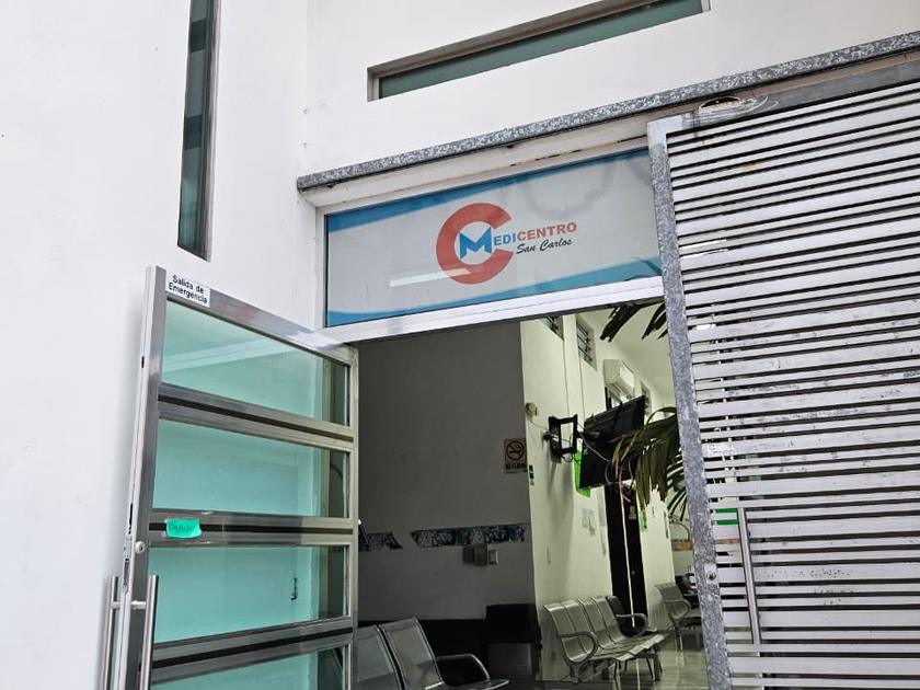 Acceso a la clínica con el logotipo de MEDICENTRO San Carlos sobre la entrada y la sala de espera al fondo