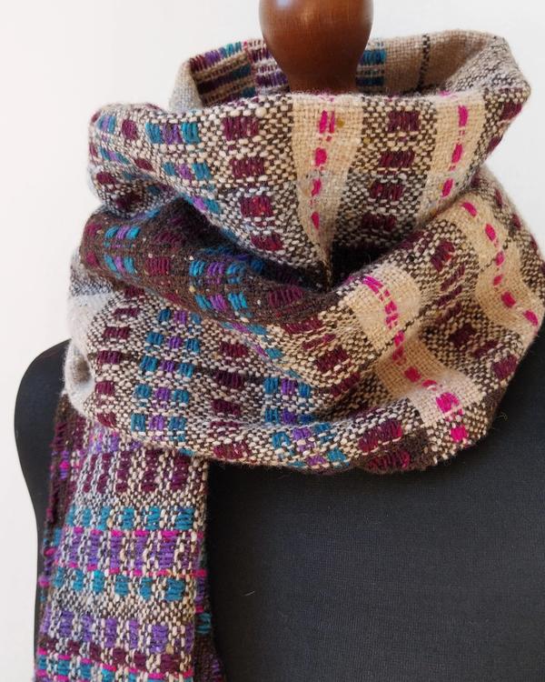 Handwoven wide shawl in turquoise, violet, burgundy-purple and fuchsia tones set against natural beige and grey shades. Colourful composition inspired by stained-glass light.