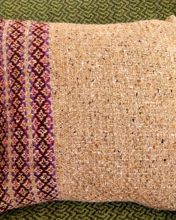 Handwoven wool cushion cover inspired by a 1907 pattern, rustic design with natural tones and purple details