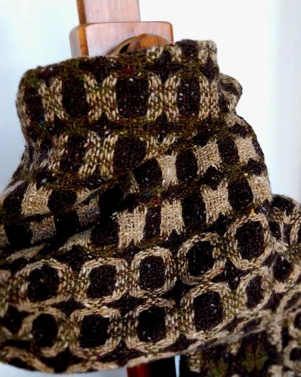 Handwoven merino wool scarf in olive green, brown and camel tones, featuring a textured geometric pattern inspired by nature and woodland camouflage
