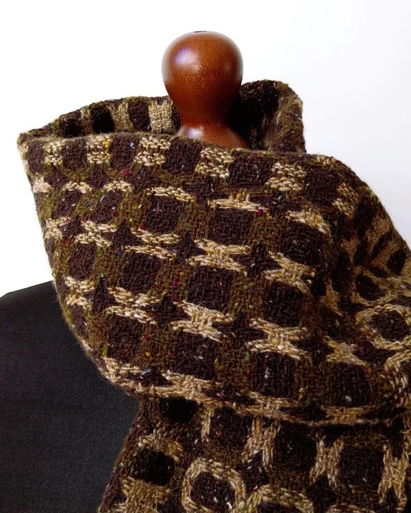 Handwoven merino wool scarf in olive green, brown and camel tones, featuring a textured geometric pattern inspired by nature and woodland camouflage