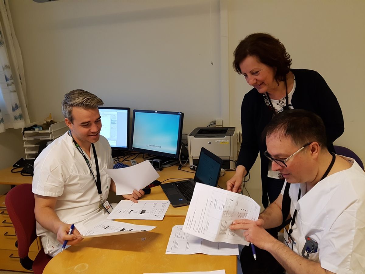 Dr. Kristoffer Simensen (left) and head doctor Nenad Damjanic, rheumatology department, are aided by projected leader Heidi Halvåg in getting familiar with the user-manual in preparation for testing. Photo: Sykehuset Østfold