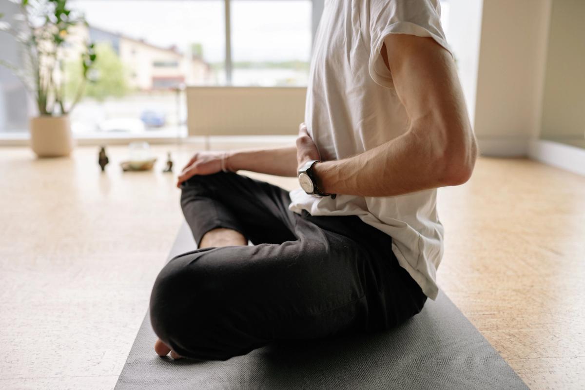 Person sitting on floor meditating