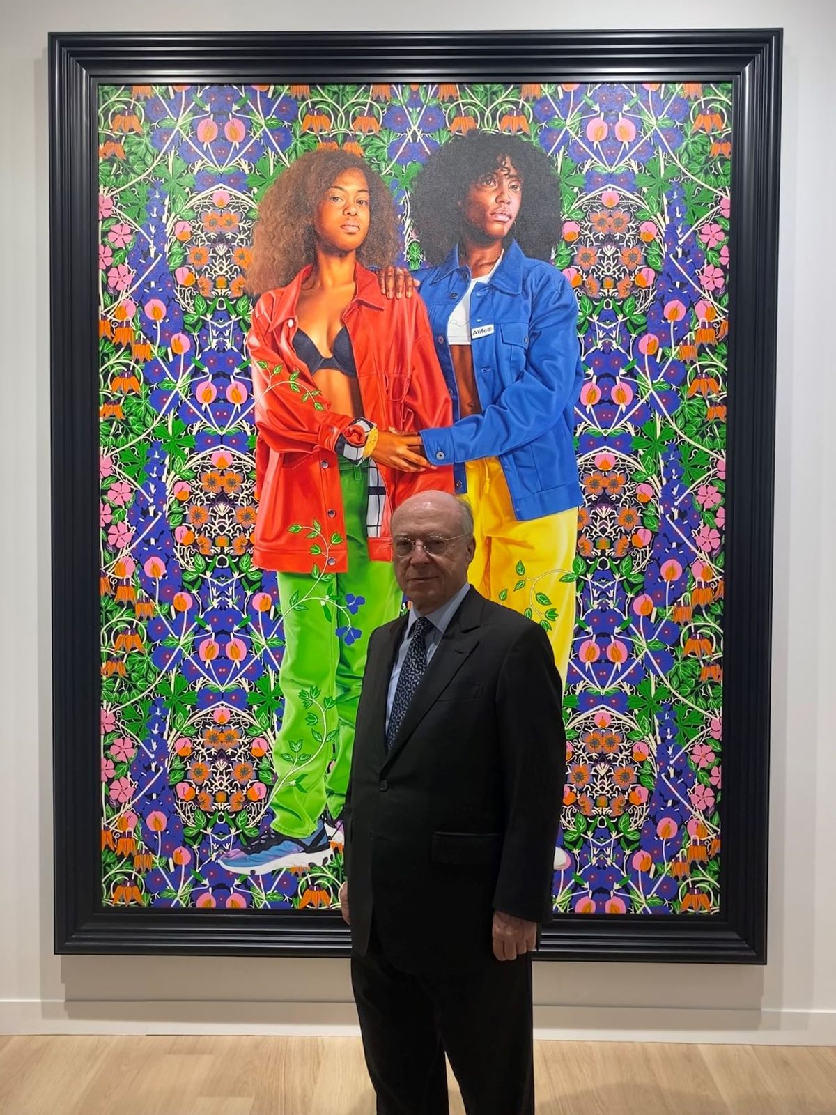 Daniel Templon sur le stand de la galerie à la FIAC devant Portrait of Jesenia Pineda & Sable Boykin (2021) de Kehinde Wiley. Courtesy galerie Templon.