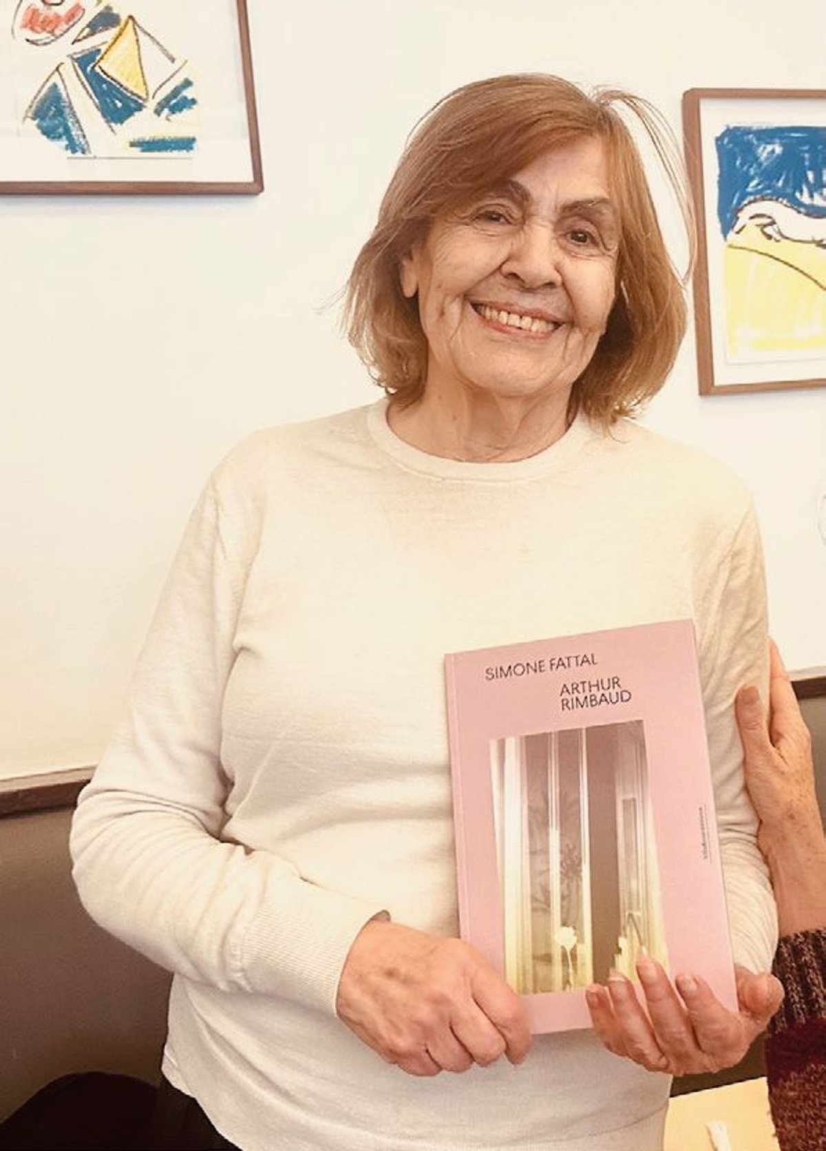 Simone Fattal tenant l’ouvrage Ce qu’on dit au Poète à propos des fleurs d’Arthur Rimbaud qu’elle a illustré, paru aux éditions VillaRrose, en 2025. Photo Karen de Loisy