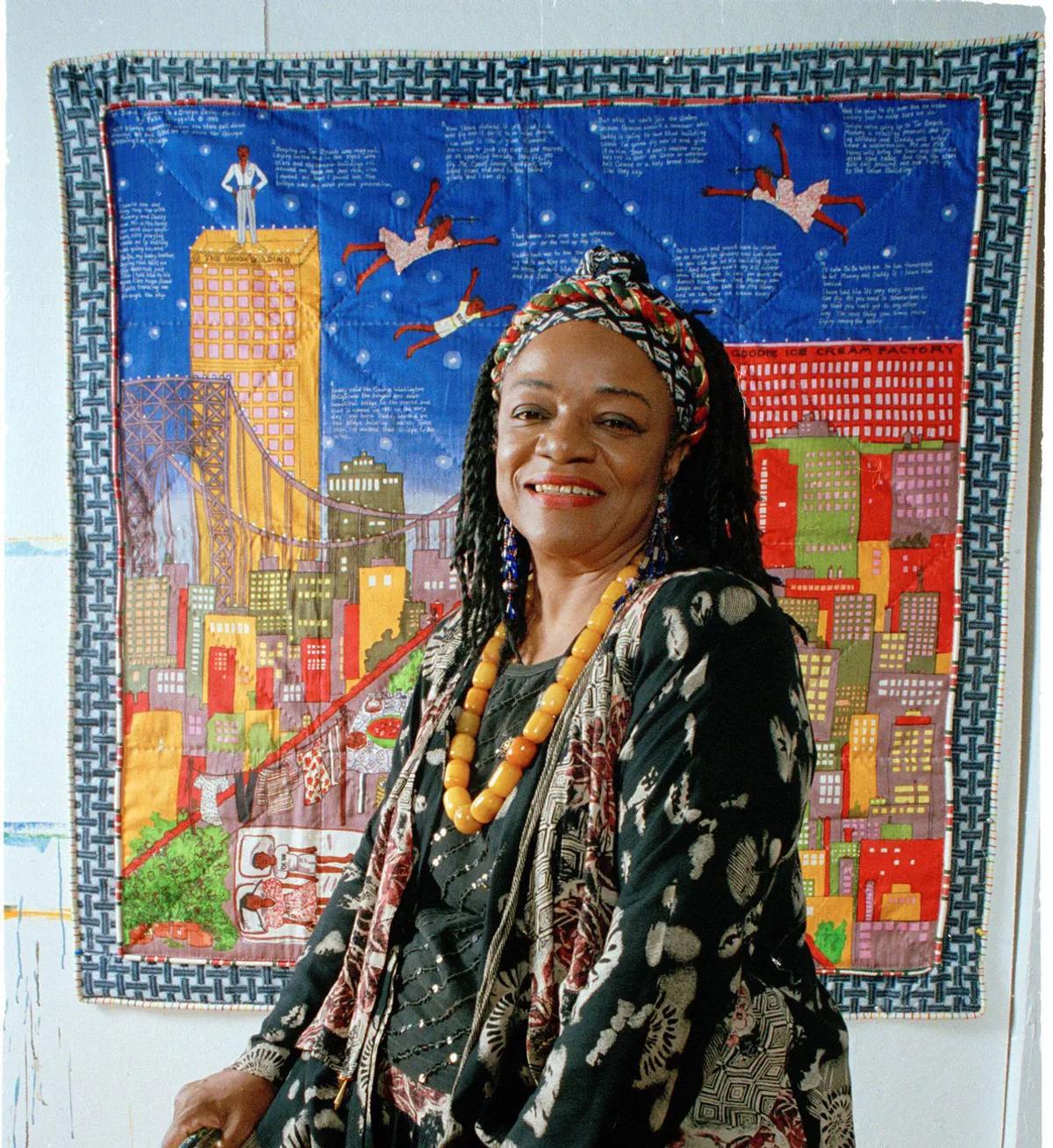 Faith Ringgold devant une œuvre de sa série Woman on a Bridge dans son atelier de New York, en juillet 1993. Photo : AP Photo/Kathy Willens.  © 2024 Faith Ringgold/Artists Rights Society (ARS), New York and DACS, London. Courtesy ACA Galleries