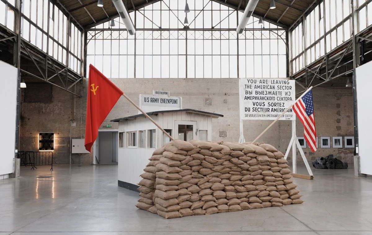 Emilio López-Menchero, Checkpoint Charlie, 2010, installation in situ, cabane, drapeaux, sacs et panneaux, BPS22, Charleroi. Courtesy de l’artiste et de la Province de Hainaut. Photo Leslie Artamonow