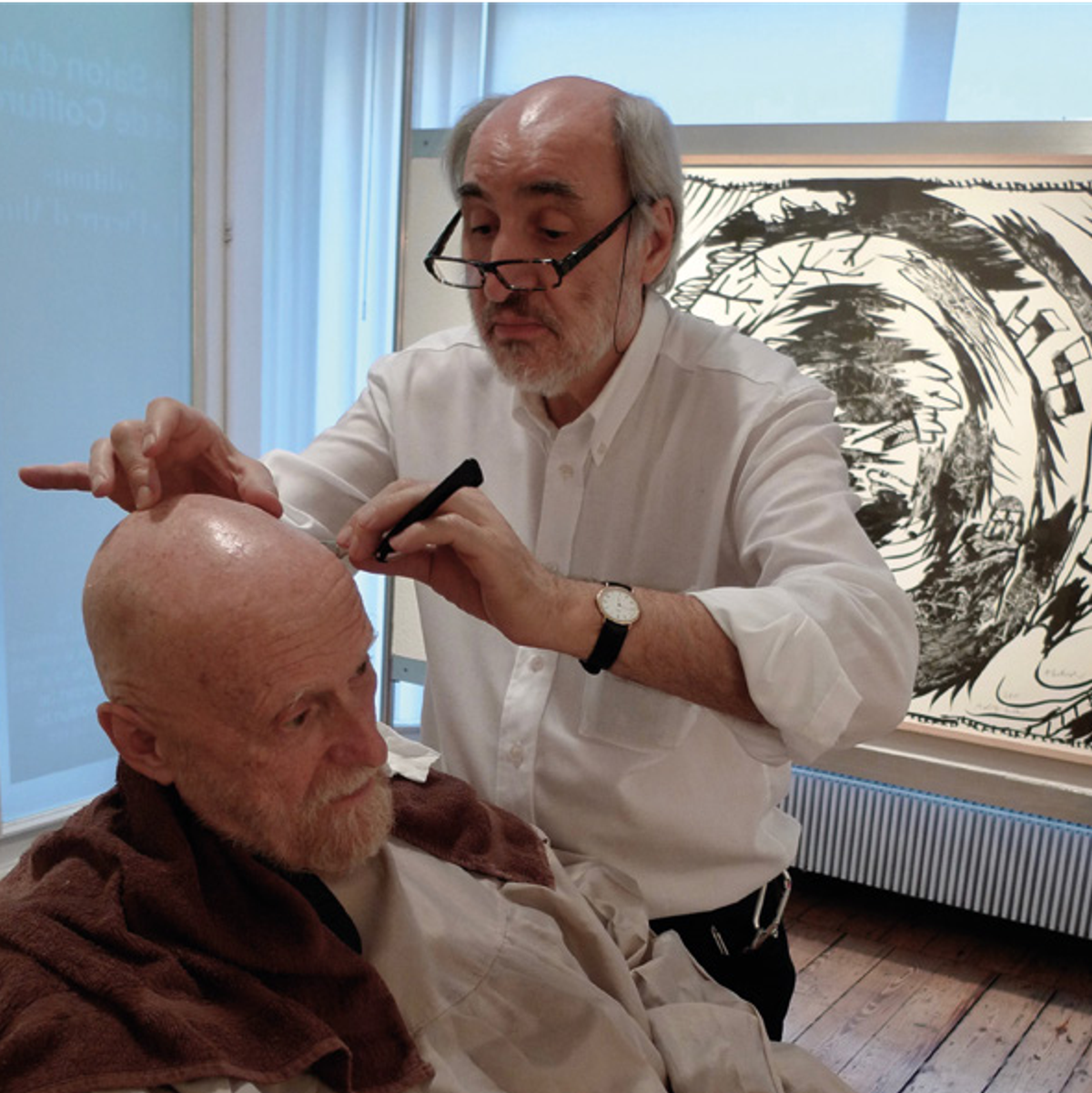 Jean Marchetti coiffant Pierre Alechinsky au Salon d’art, à Bruxelles, le 22 octobre 2012, à l’occasion du vernissage de l’exposition « Alechinsky. Le Combat avec l’âge. Travaux récents ». © Photo Alain Delaunois/The Sam Spooner