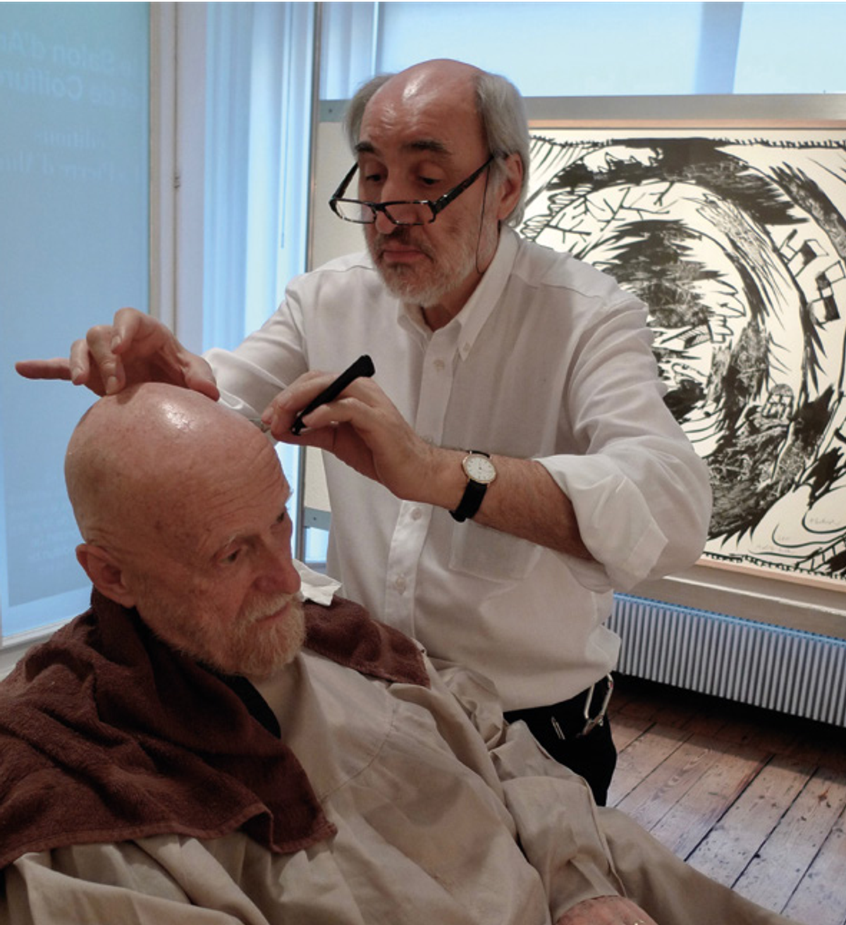 Jean Marchetti coiffant Pierre Alechinsky au Salon d’art, à Bruxelles, le 22 octobre 2012, à l’occasion du vernissage de l’exposition « Alechinsky. Le Combat avec l’âge. Travaux récents ». © Photo Alain Delaunois/The Sam Spooner