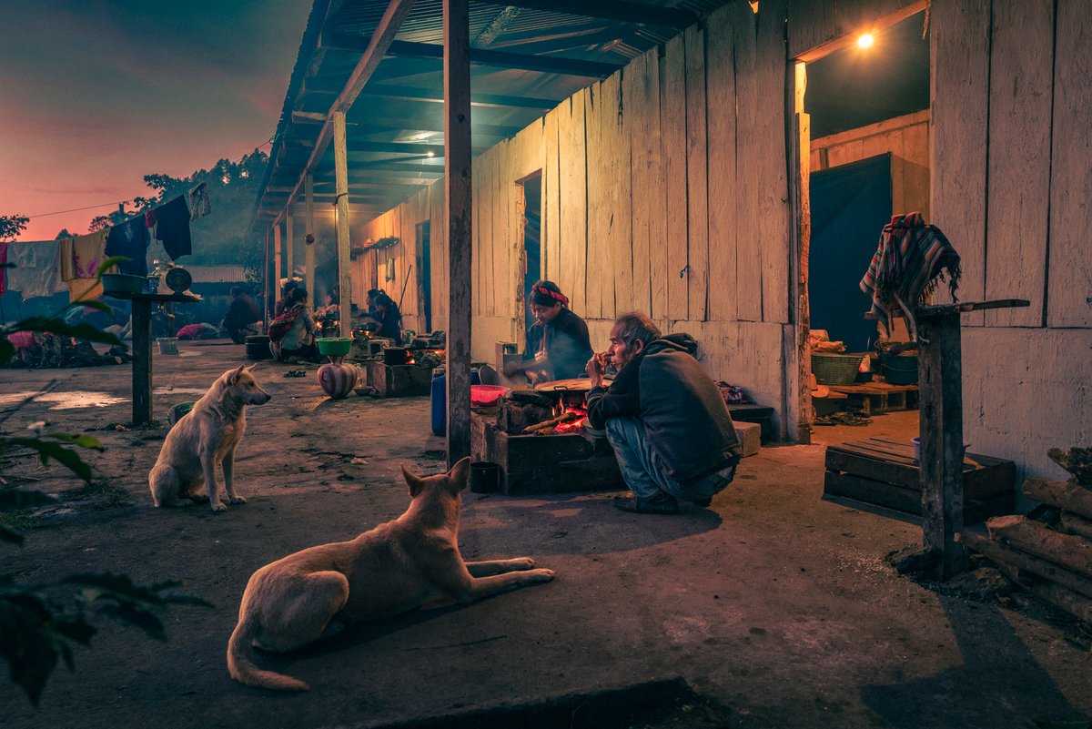 Lys Arango, Trois familles de travailleurs saisonniers prennent leur petit-déjeuner sous le porche du dortoir où elles résident pendant des mois plantation de café, San Antonio Huista, dans le département de Huehuetenango, au Guatemala. © Lys Arango